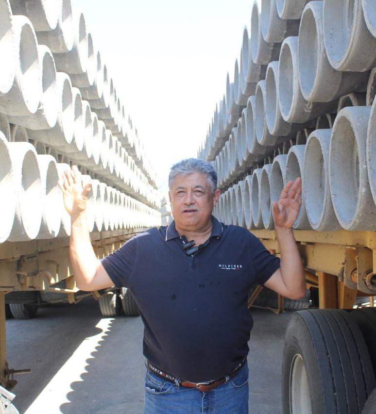 Trabajadores en la descarga de tuberías de concreto.